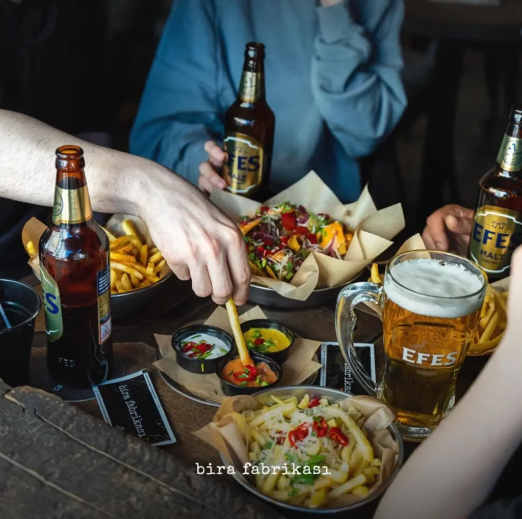 beer cips on a table and people are dipping their cips into sauce
