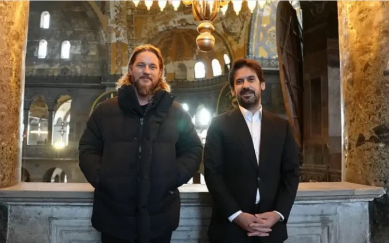 Actor Travis Fimmel and Minister Dr. Batuhan Mumcu standing together inside the historical Ayasofya Museum in Istanbul.